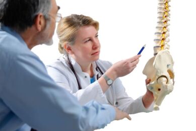 Az orvos konzultál a pácienssel a mellkasi gerinc osteochondrosisának jeleiről
